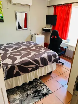 a bedroom with a bed and a desk and a chair at Kasi Retreat in Northam