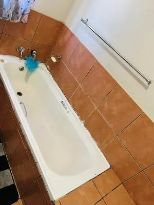 a bath tub in a bathroom with a tiled floor at Kasi Retreat in Northam