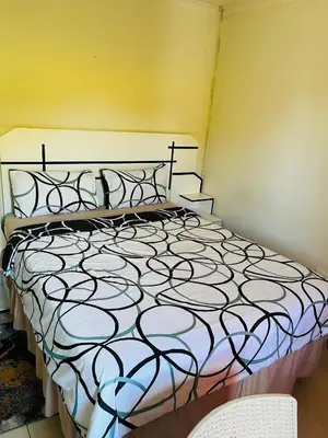 a bed with a black and white comforter in a room at Kasi Retreat in Northam