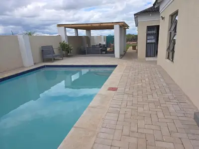 a swimming pool with a pergola next to a house at Bigmor guesthouse Eldorado