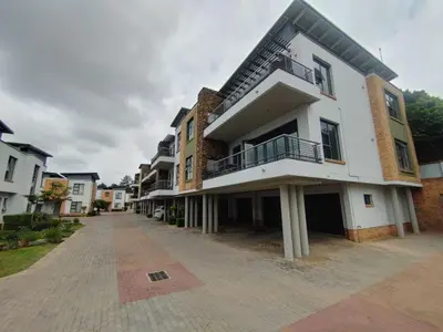 a large white building with balconies on a street at Perfect place for family in Pretoria