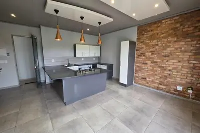 a large kitchen with a counter and a brick wall at Perfect place for family in Pretoria