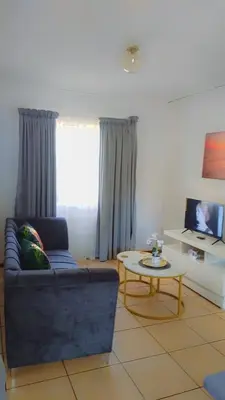 a living room with a blue couch and a table at Yolipopsta stays in Kempton Park