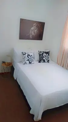 a white bed with pillows on it in a room at Yolipopsta stays in Kempton Park