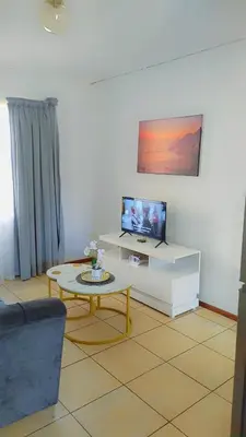 a living room with a tv and a coffee table at Yolipopsta stays in Kempton Park