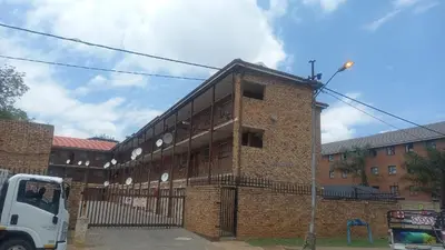 a brick building with a white truck parked in front of it at Yolipopsta stays in Kempton Park