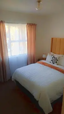 a bedroom with a large bed and a window at Yolipopsta stays in Kempton Park
