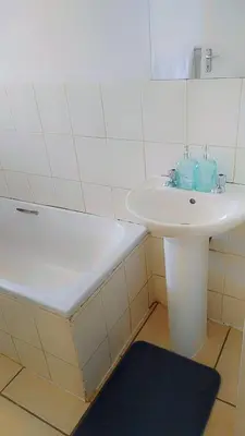 a bathroom with a sink and a bath tub at Yolipopsta stays in Kempton Park