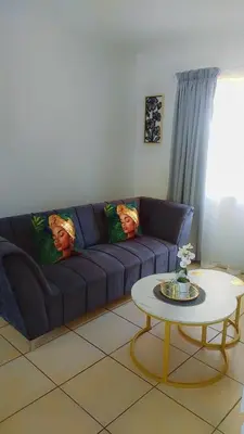 a living room with a blue couch and a table at Yolipopsta stays in Kempton Park