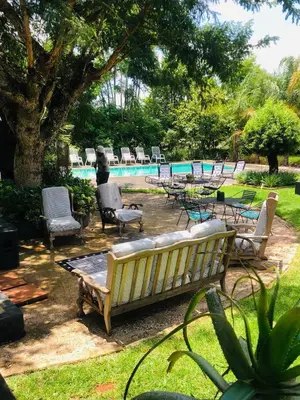 a bench and chairs next to a swimming pool at SPAat343 in Roodeplaat