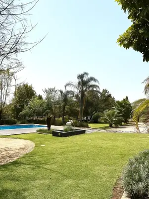 a person standing in the grass near a swimming pool at SPAat343 in Roodeplaat