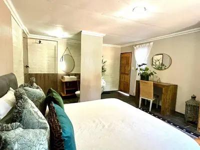 a bedroom with a bed and a table and a desk at SPAat343 in Roodeplaat