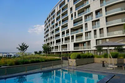 a large building with a swimming pool and an umbrella at Elipse Waterfall Luxe Executive Apartment in Midrand