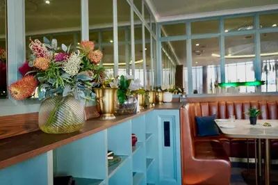 a restaurant with a counter with a vase of flowers at Elipse Waterfall Luxe Executive Apartment in Midrand
