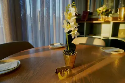 a vase of flowers sitting on top of a wooden table at Elipse Waterfall Luxe Executive Apartment in Midrand