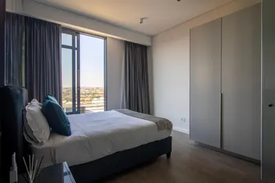 a bedroom with a bed and a large window at Menlyn Pretoria 732 in Pretoria