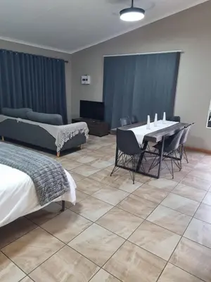 a room with a table and chairs and a couch at Sunset Retreat in Polokwane