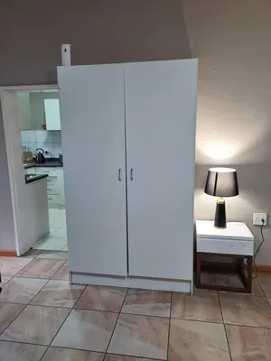 a large white cabinet in a room with a lamp at Sunset Retreat in Polokwane