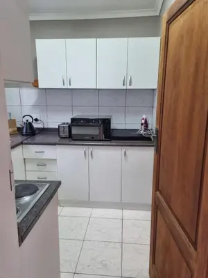 a kitchen with white cabinets and a sink at Sunset Retreat in Polokwane
