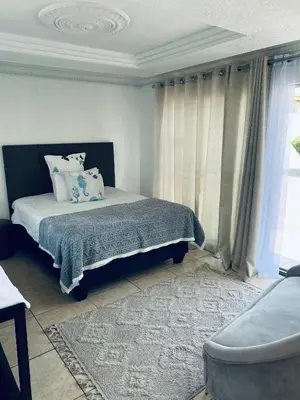 a bedroom with a bed and a large window at Euphoria Escape in Midrand