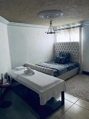 a bedroom with a bed with a window and a table at Euphoria Escape in Midrand
