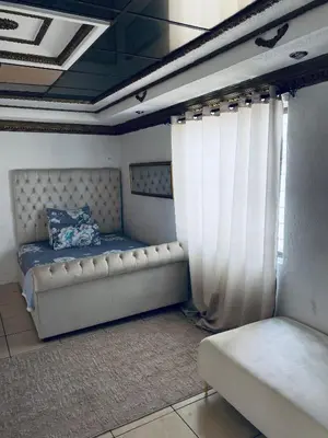a room with a bed and curtains and a couch at Euphoria Escape in Midrand