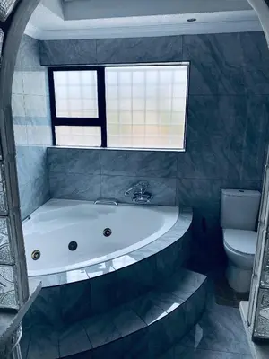 a bathroom with a bath tub and a toilet at Euphoria Escape in Midrand