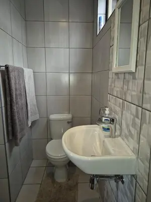 a white bathroom with a toilet and a sink at Close to O R Tambo Airport Alderlane 1 in Kempton Park
