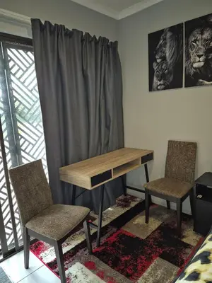 a desk and two chairs in a room with a window at Close to O R Tambo Airport Alderlane 1 in Kempton Park