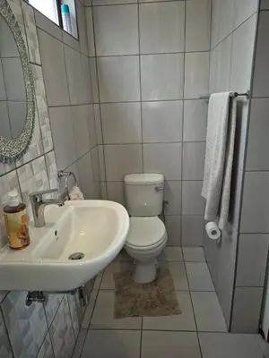 a bathroom with a white toilet and a sink at Close to O R Tambo Airport Alderlane 1 in Kempton Park