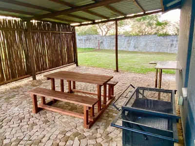 a picnic table and bench on a patio at Menatwork contractors accommodation in Nelspruit