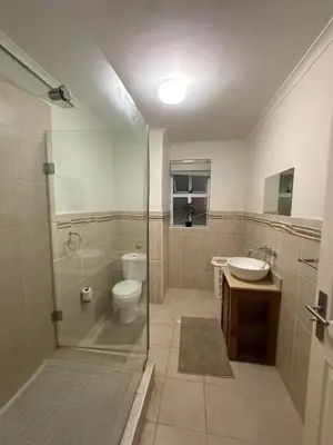 a bathroom with a shower and a toilet and a sink at The Oxford Haven