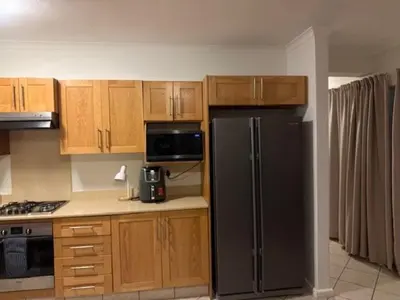 a kitchen with a black refrigerator and wooden cabinets at The Oxford Haven
