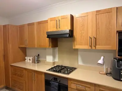 a kitchen with wooden cabinets and a stove top oven at The Oxford Haven