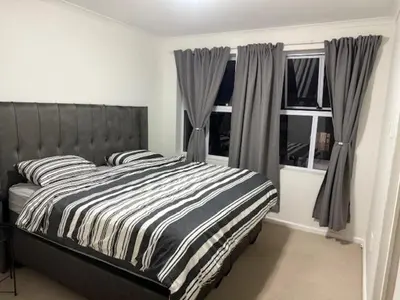 a bedroom with a bed with a striped comforter and windows at The Oxford Haven
