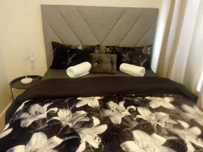 a bed with a black and white blanket and pillows at The Oxford Haven