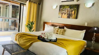 a hotel room with a bed with shoes on it at La Dolce Vita Lodge in Hoedspruit