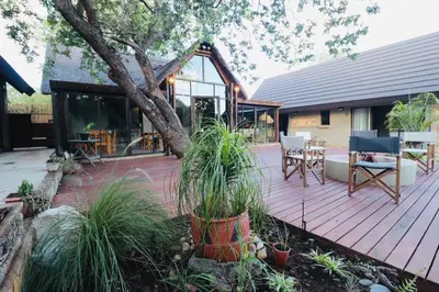 a wooden deck with a table and chairs on it at La Dolce Vita Lodge in Hoedspruit