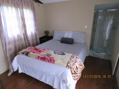 a bedroom with a bed with a bag on it at Klein Paradys Lodge - Polokwane in Polokwane