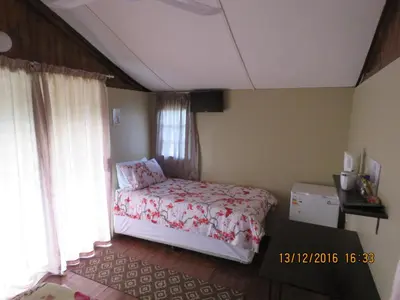 a bedroom with a bed and a window at Klein Paradys Lodge - Polokwane in Polokwane