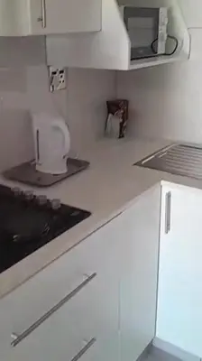 a kitchen with a white counter top with a sink at Ermelo Executive Rooms in Ermelo