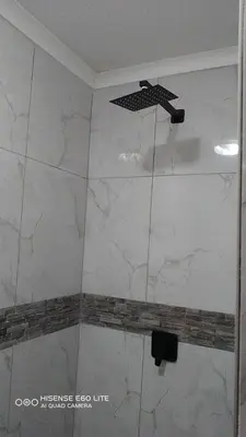 a shower with white marble walls and a ceiling at Ermelo Executive Rooms in Ermelo
