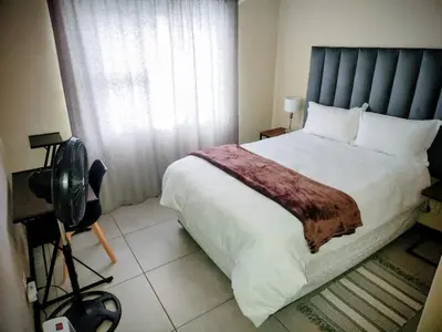 a bedroom with a large bed and a camera at Lovely one bedroom apartment in Midrand