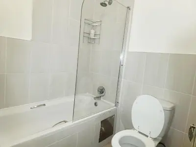 a white bathroom with a toilet and a shower at Lovely one bedroom apartment in Midrand