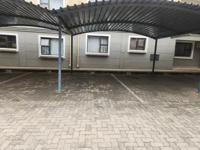 an empty parking lot with a building with windows at Lovely one bedroom apartment in Midrand