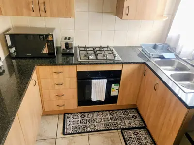 a small kitchen with a stove and a sink at Lovely one bedroom apartment in Midrand