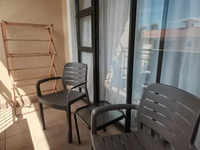 two chairs sitting on a balcony next to a window at Lovely one bedroom apartment in Midrand
