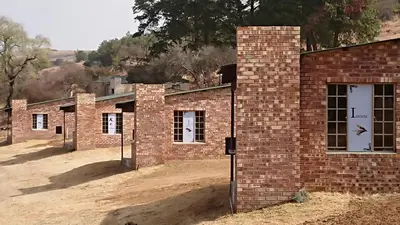 a row of brick buildings in a field at Elandskloof Trout Farm in Dullstroom