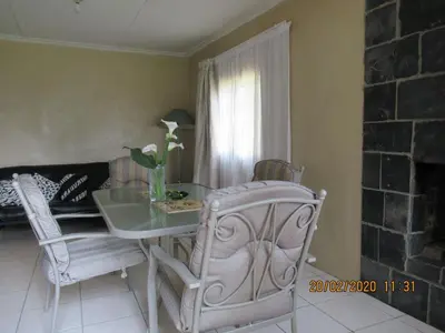 a dining room with a glass table and chairs at Elandskloof Trout Farm in Dullstroom