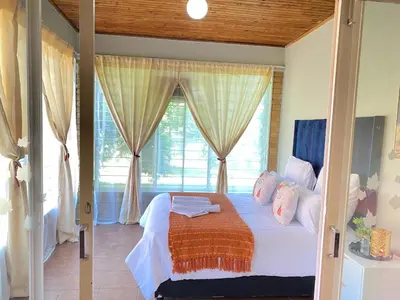 a bedroom with a bed and a large window at Ranx Guest House in Pretoria